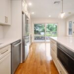 Cream kitchen cabinets with quartz countertops and stainless appliances