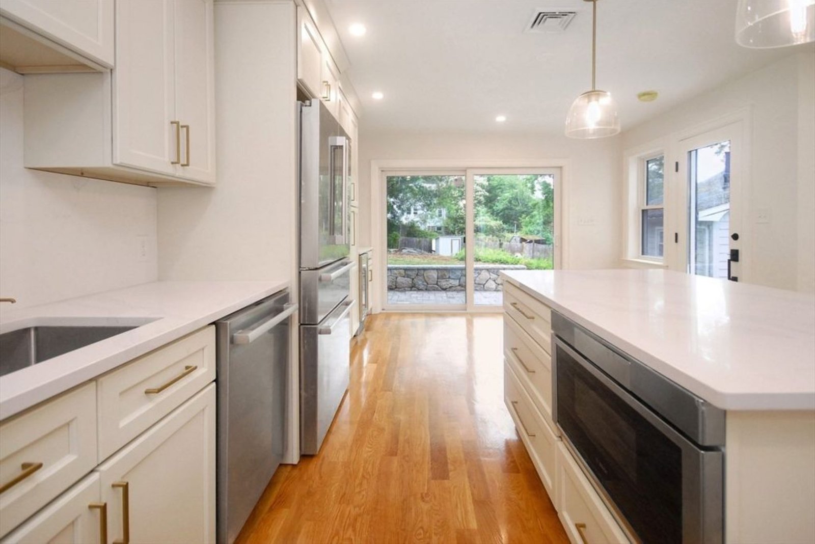 Cream kitchen cabinets with quartz countertops and stainless appliances