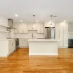 Cream shaker kitchen with island and brass pendant lights