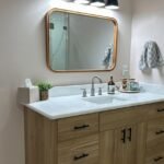 White oak bathroom vanity with black hardware and stone countertop