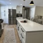 Kitchen island with quartz countertop and black-and-brass pendant lights