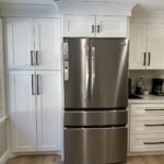 White shaker pantry cabinets surrounding a stainless refrigerator
